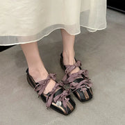 Mary Jane Ballet Flats Round Toe Low Heel Black Purple Lace-up stylishly worn with a flowy dress.